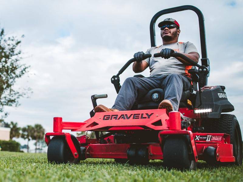 Expert Mowing on a Sunny Day Man using a riding lawn mower in a well-manicured garden.
