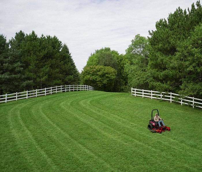 Efficient Lawn Mowing by Expert with Gas Mower Adult man engaging in lawn care with a powerful gas-powered mower.